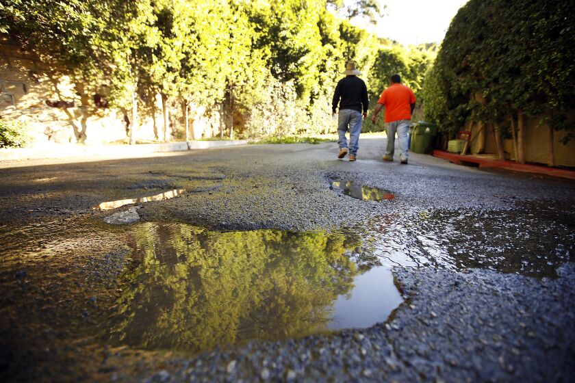 Pot holes fill with running water in the streets surrounding homes in the Bel Air neighborhood of Los Angeles on October 21.
