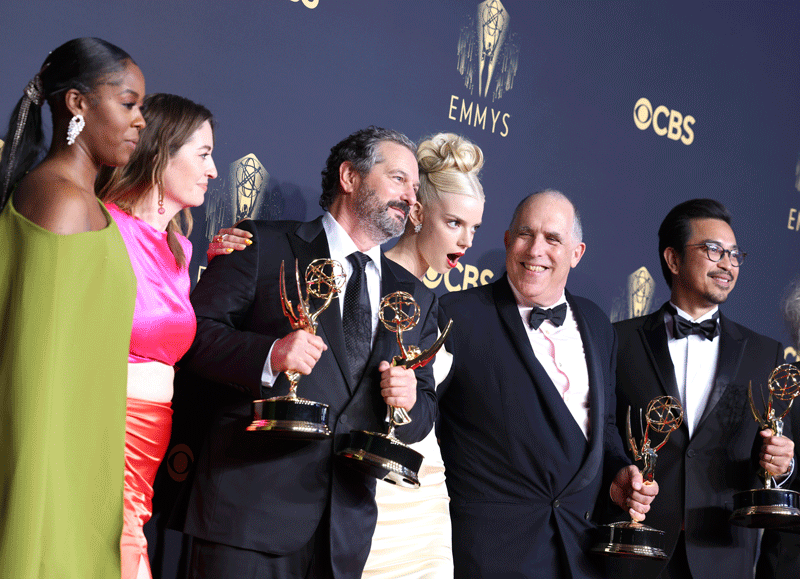Gif of actors and crew members from winning shows posing with their Emmy statues.