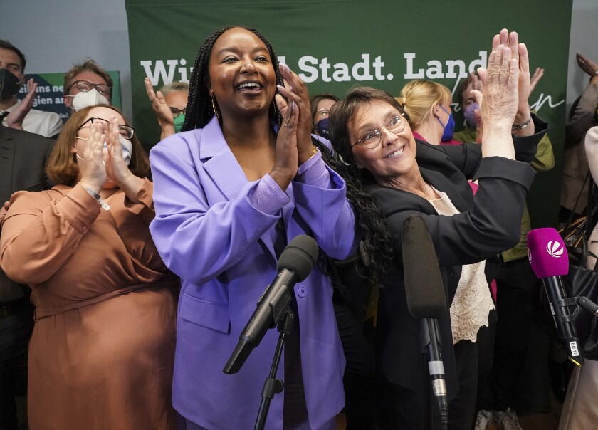 FILE - Aminata Toure, center, applauds after the first forecasts for the state election in Schleswig-Holstein were announced, in Kiel, Germany, May 8, 2022. The daughter of two Malian refugees has become the first black member of a state government in Germany. Aminata Toure was named Wednesday, June 29 to the Cabinet of Governor Daniel Guenther of Germany's northernmost state of Schleswig-Holstein, on the border with Denmark. (Marcus Brandt/dpa via AP, file)