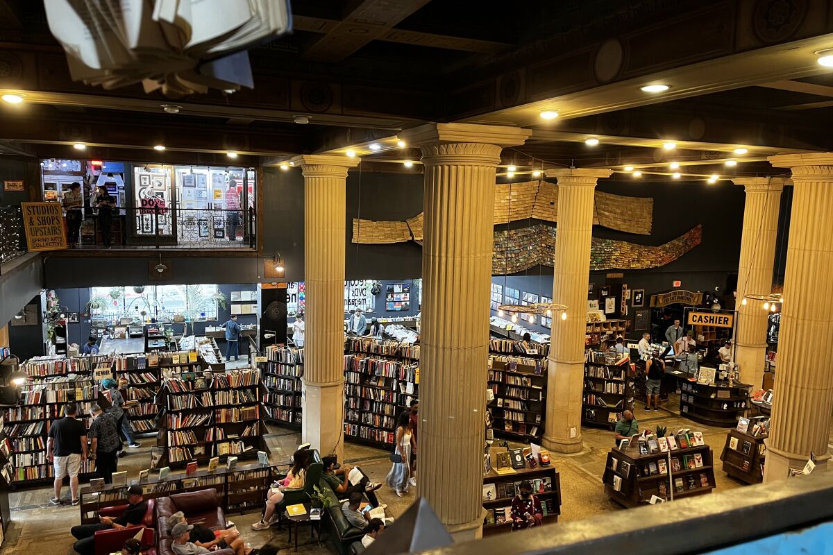 Visitors relax on lounge chairs and explore the stacks at the Last Bookstore.