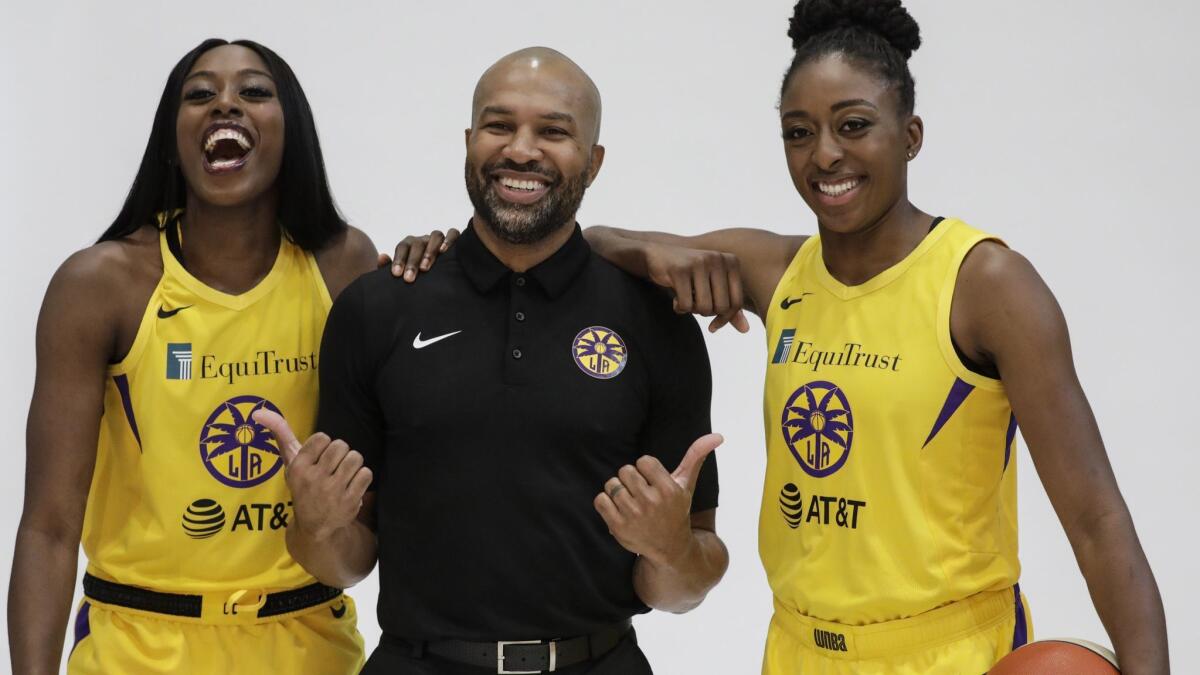 Sparks coach Derek Fisher poses for a photo with sisters Chiney, left, and Nneka Ogwumike during media day.