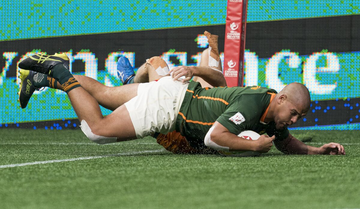 South Africa's Zain Davids dives into the try zone to score a try against Australia during a Canada Sevens rugby match in Vancouver, British Columbia, Saturday, April 16, 2022. (Rich Lam/The Canadian Press via AP)