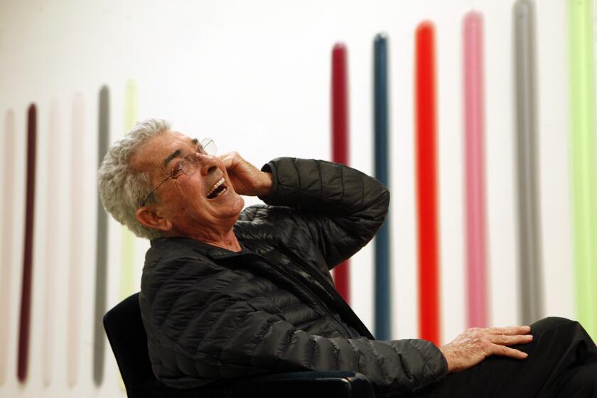 SANTA MONICA, CA - MARCH 27, 2014 --Artist Peter Alexander, seated in front of his work, enjoys a light moment in his studio in Santa Monica on March 27, 2014. Alexander became rapidly renowned for his exploration of transparency and color in his polyester sculptures. Inspired by the California light and ocean, his atmospheric pieces create ever-shifting viewing experiences. In the early 1970, Alexander stopped working in polyester to dedicate himself to painting. In the 2000s, he discovered polyurethane, which allowed him to return to sculpture and continue his explorations of the properties of color without the downsides of polyester (e.g. toxicity, brittleness, yellowing). Rachel Rivenc, a scientist at the Getty Conservation Institute, is developing protocols for saving the work of Alexander, along with other artists like Larry Bell and Craig Kaufmann. (Genaro Molina/Los Angeles Times)