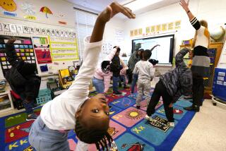First grader Amora Speid, left, stretches out during classes at Chimborazo Elementary School Thursday, Nov. 17, 2022, in Richmond, Va. The Richmond school district, which includes Chimborazo elementary, ultimately decided against year-round school. (AP Photo/Steve Helber)