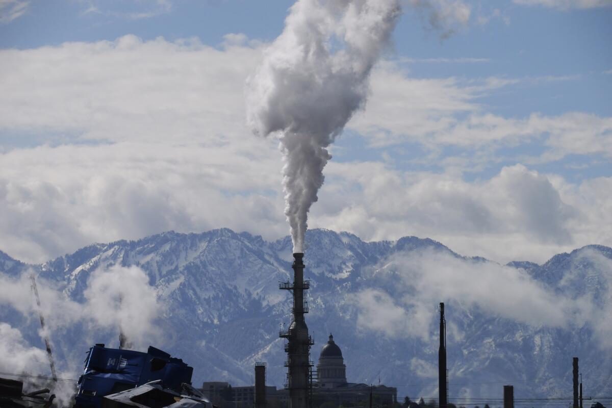 FILE - The Utah State Capitol, rear, is shown behind an oil refinery on Thursday, May 12, 2022, in Salt Lake City. President Joe Biden is promising “strong executive action” to combat climate change, despite dual setbacks that have restricted his ability to regulate carbon emissions and boost clean energy such as wind and solar power. (AP Photo/Rick Bowmer, File)