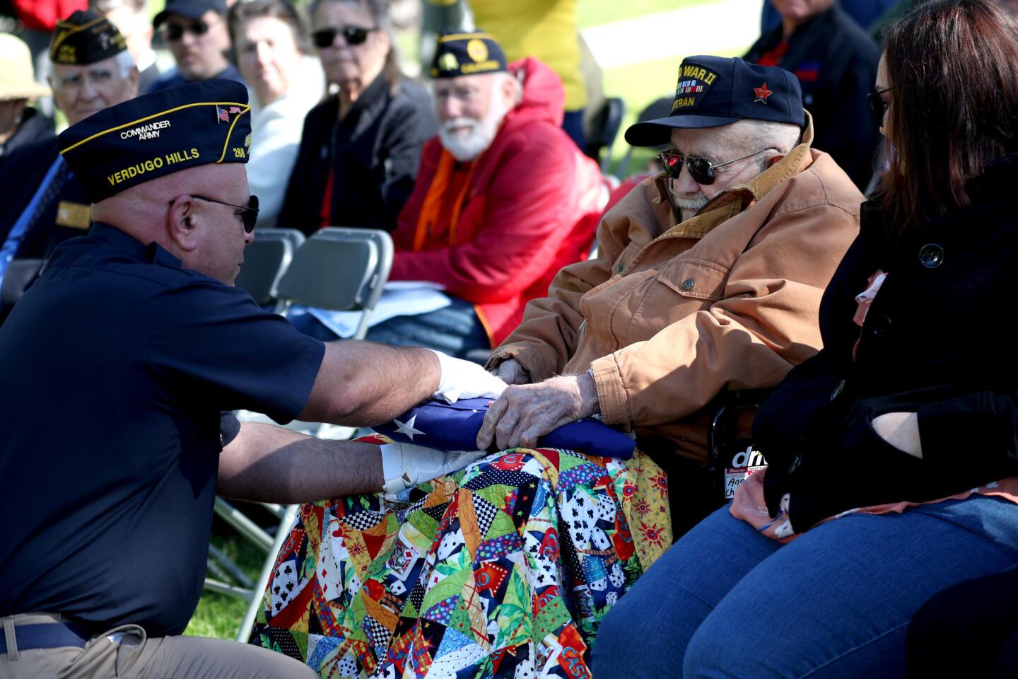 American Legion Post 288 color guard member Darren Azarian, left, presents flag to World War II veteran Angelo Chairot, in honor of his brother and Vietnam War veteran Roy Chairot, during the annual Memorial Day Service at Two Strike Park Memorial Wall in La Crescenta on Monday, May 27, 2019.