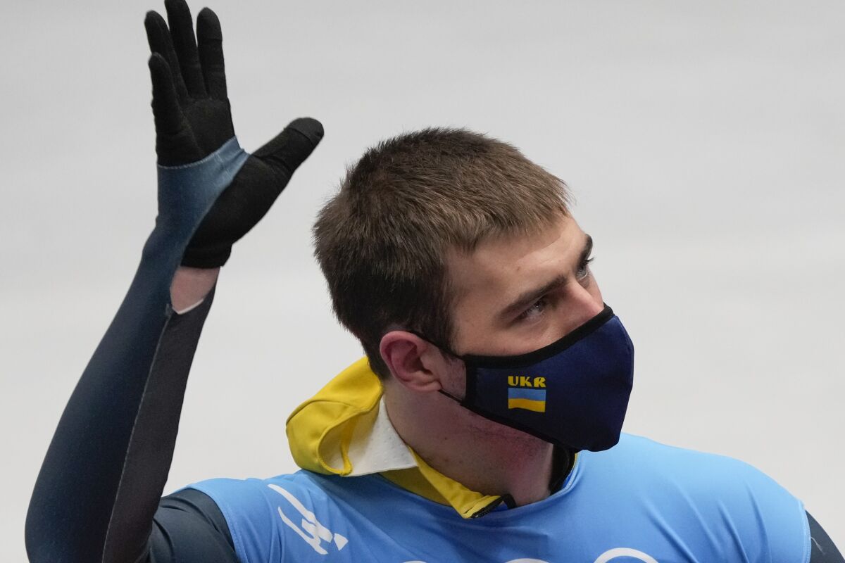 Vladyslav Heraskevych, of Ukraine, waves after finishing the men's skeleton run 4 at the 2022 Winter Olympics, Friday, Feb. 11, 2022, in the Yanqing district of Beijing. (AP Photo/Dmitri Lovetsky)