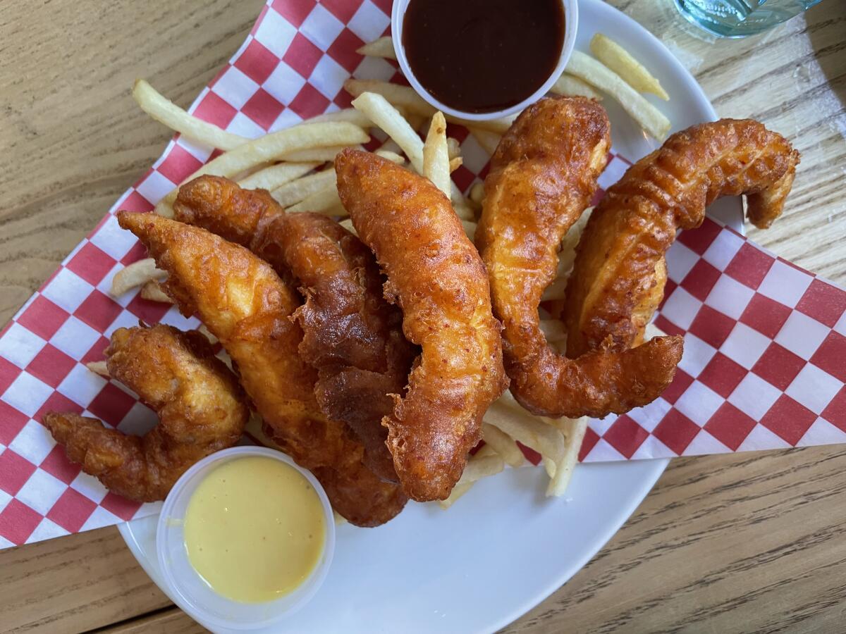 Chicken tenders, fries and dipping sauce on a plate. 