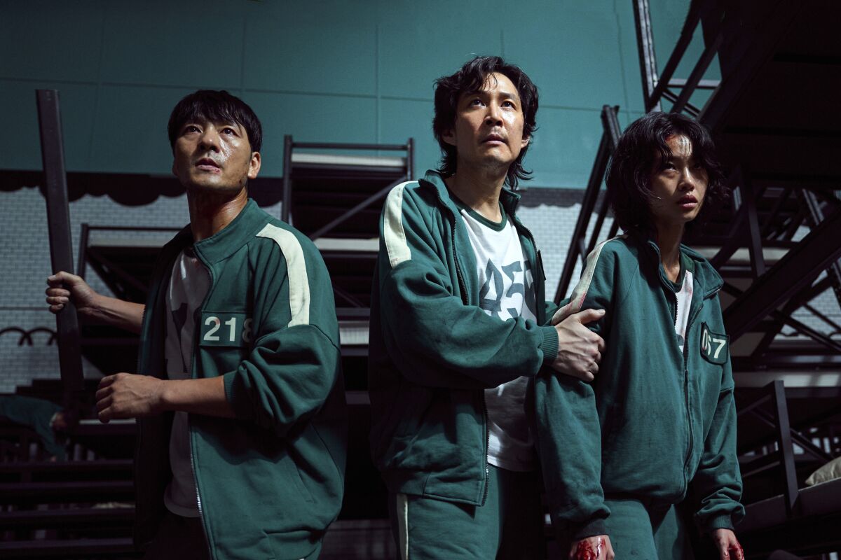 This undated photo released by Netflix shows South Korean cast members, from left, Park Hae-soo, Lee Jung-jae and Jung Ho-yeon in a scene from "Squid Game." Squid Game, a globally popular South Korea-produced Netflix show that depicts hundreds of financially distressed characters competing in deadly children’s games for a chance to escape severe debt, has struck a raw nerve at home, where there’s growing discontent over soaring household debt, decaying job markets and worsening income inequality. (Youngkyu Park/Netflix via AP)