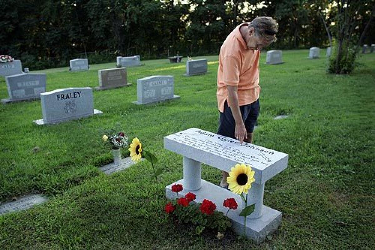 Teddy Johnson traces his fingers along his son's name at his grave site. Adam, a college student and musician, died of a black-tar overdose, and his father found the young man's body. "I had no clue," Teddy Johnson said. "We're a small town. We weren't prepared."