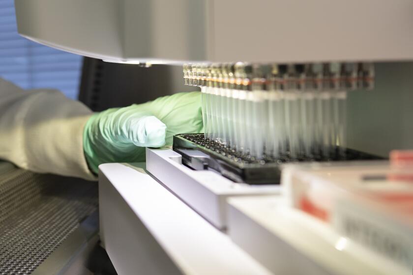 A researcher works on the development of the medication aducanumab at Biogen in Cambridge, Mass.