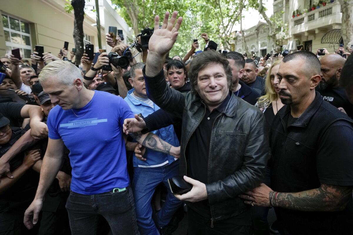 Presidential candidate Javier Milei arrives in a scrum of people to vote in in Buenos Aires.