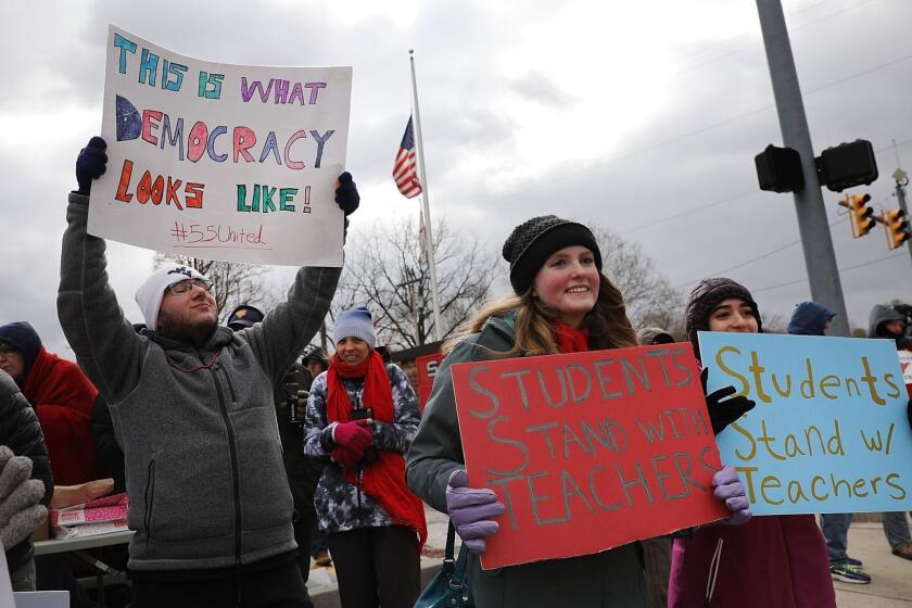 MORGANTOWN, WV - MARCH 02: West Virginia teachers, students and supporters hold signs on a Morgantown street as they continue their strike on March 2, 2018 in Morgantown, West Virginia. Despite a tentative deal reached Tuesday with the state's governor, teachers across West Virginia continued to strike on Friday as the Republican-controlled state legislature debated the governor's deal. (Photo by Spencer Platt/Getty Images) ** OUTS - ELSENT, FPG, CM - OUTS * NM, PH, VA if sourced by CT, LA or MoD **