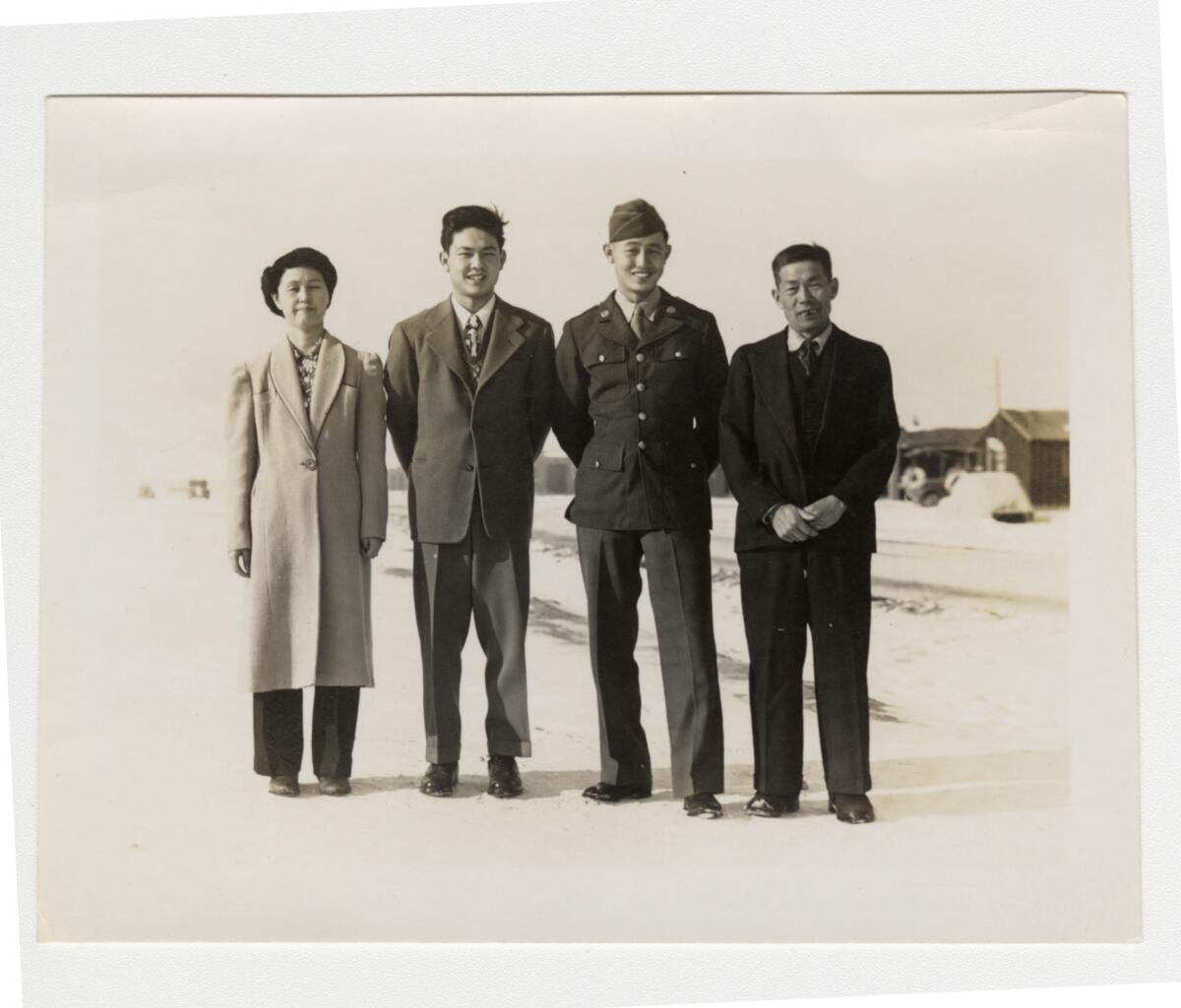 A 1940s photo shows a uniformed Japanese American soldier posed with his mother, father and brother.