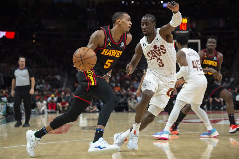 Atlanta Hawks guard Dejounte Murray dribbles to the basket as Cleveland Cavaliers guard Caris LeVert defends during the first half of an NBA basketball game Tuesday, March 28, 2023, in Atlanta. (AP Photo/Hakim Wright Sr.)