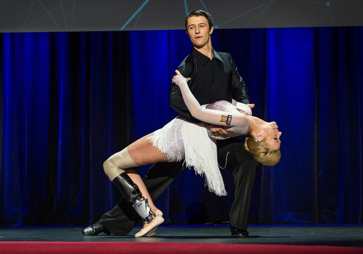 In this photo provided by the TED 2014 Conference, Adrianne Haslet-Davis performs onstage with fellow dancer Christian Lightner in Vancouver, British Columbia.