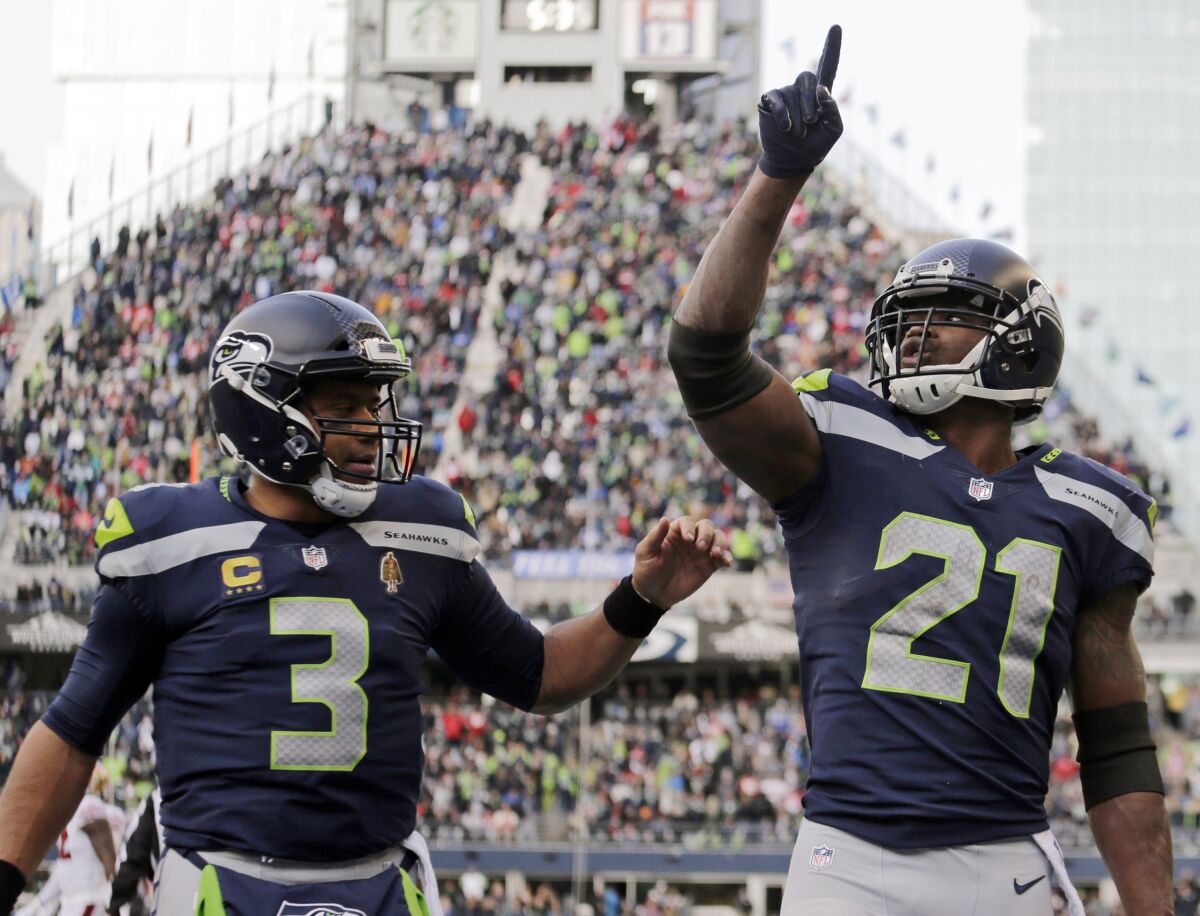 FILE - Seattle Seahawks running back Adrian Peterson (21) celebrates with quarterback Russell Wilson (3) after scoring a touchdown against the San Francisco 49ers during the first half of an NFL football game Dec. 5, 2021, in Seattle. With uncertainty surrounding the future of Wilson, Peterson believes finishing the season on a high note – Wilson threw nine touchdown passes and one interception in the final three games – will result in the quarterback staying put. (AP Photo/John Froschauer, File)