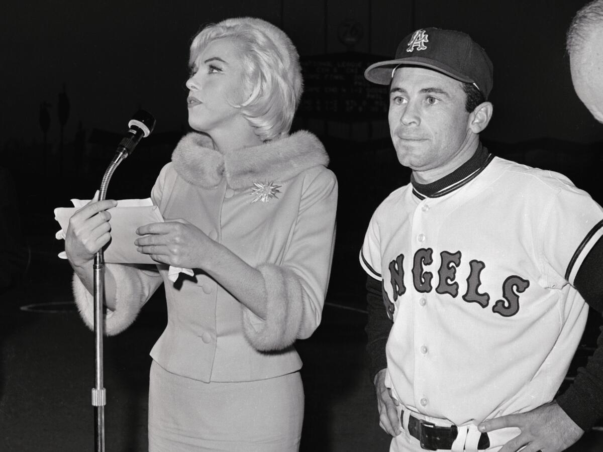 Actress Marilyn Monroe stands next to Angels outfielder Albie Pearson at Dodger Stadium in 1962.