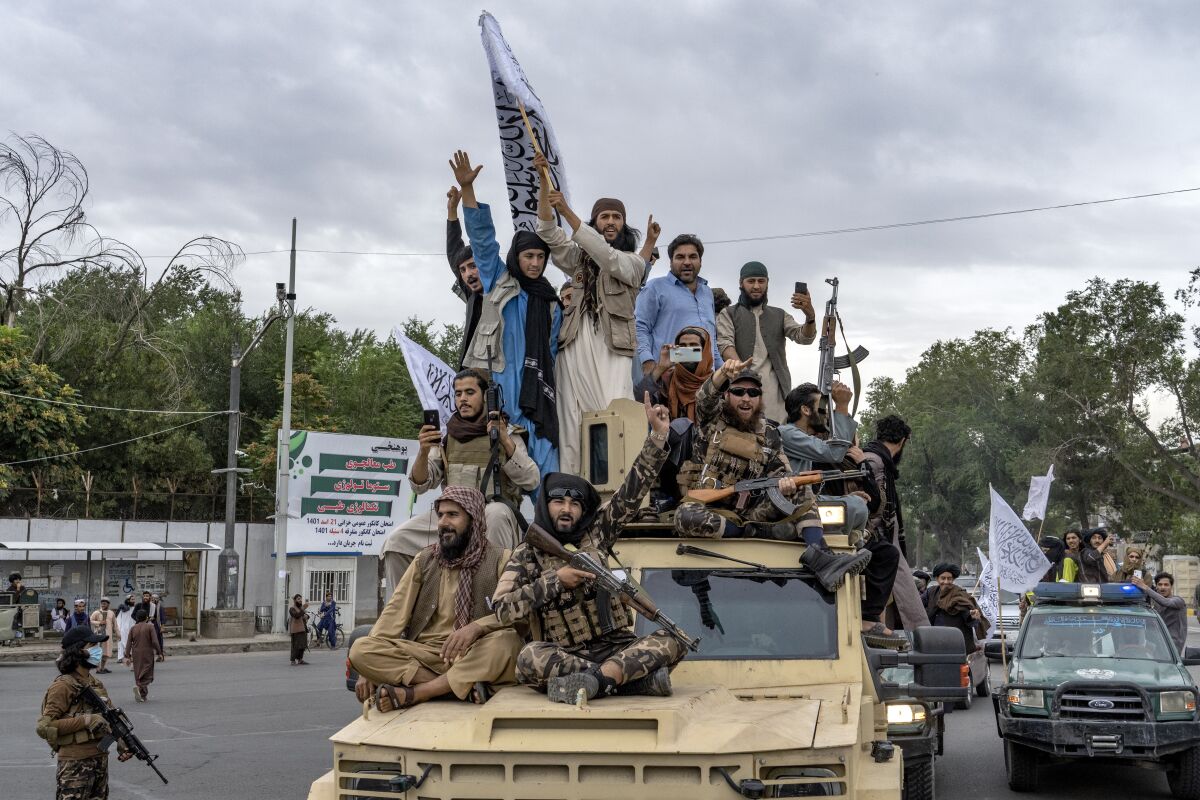 Taliban fighters celebrate one year since they seized the Afghan capital, Kabul, in front of the U.S. Embassy in Kabul, Afghanistan, Monday, Aug. 15, 2022. (AP Photo/Ebrahim Noroozi)