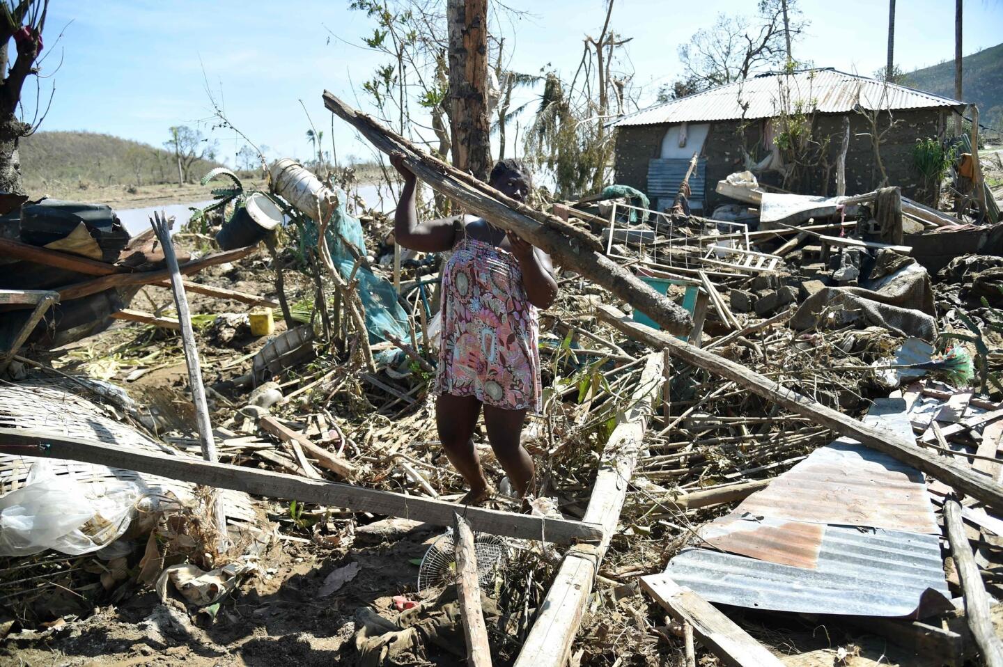 Sasa, 25, takes the remains of her house destroyed by Hurricane Matthew to build another in a nearby field in Jeremie, Haiti on Oct. 8, 2016.