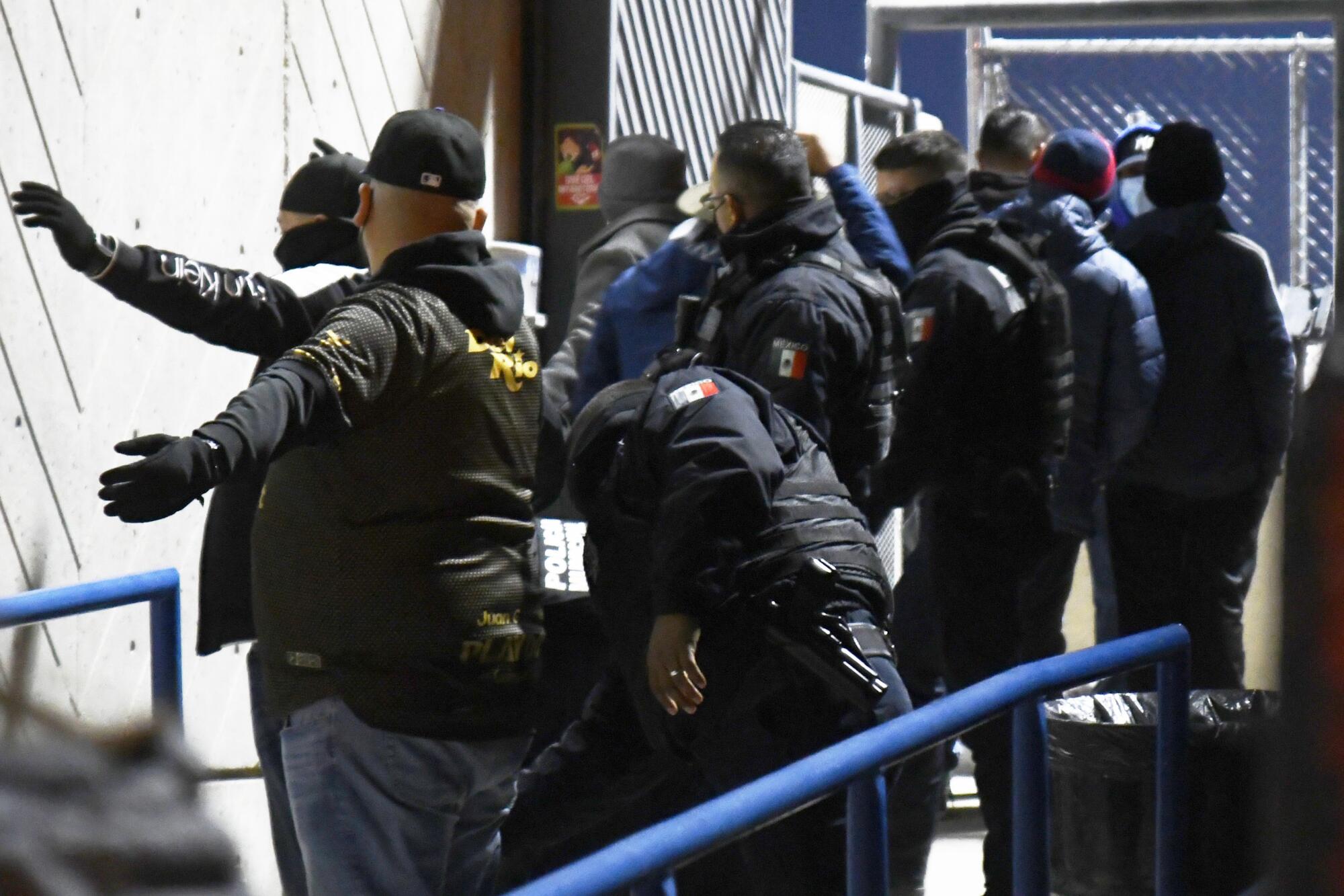 Police officers check fans before their access.