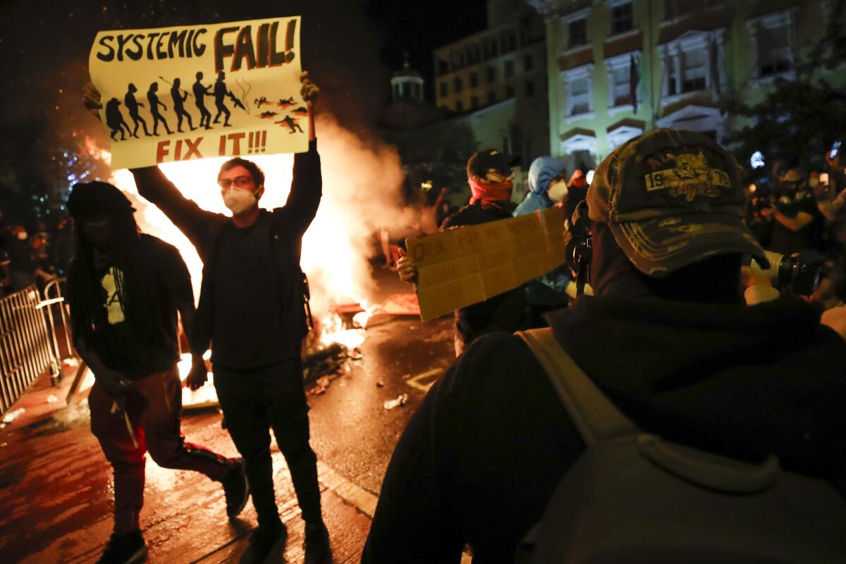 Demonstrators protest the death of George Floyd, Sunday, May 31, 2020, near the White House in Washington. Floyd died after being restrained by Minneapolis police officers.