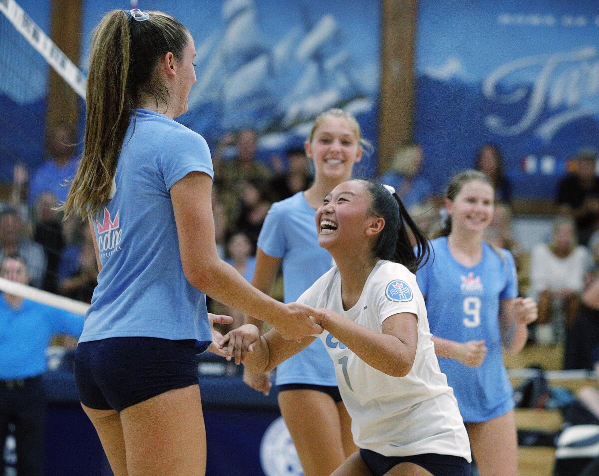 Corona del Mar's Molly Joyce, left, is congratulated by teammate Michelle Won after hitting a cross-court kill at Newport Harbor in the Battle of the Bay match on Sept. 12.