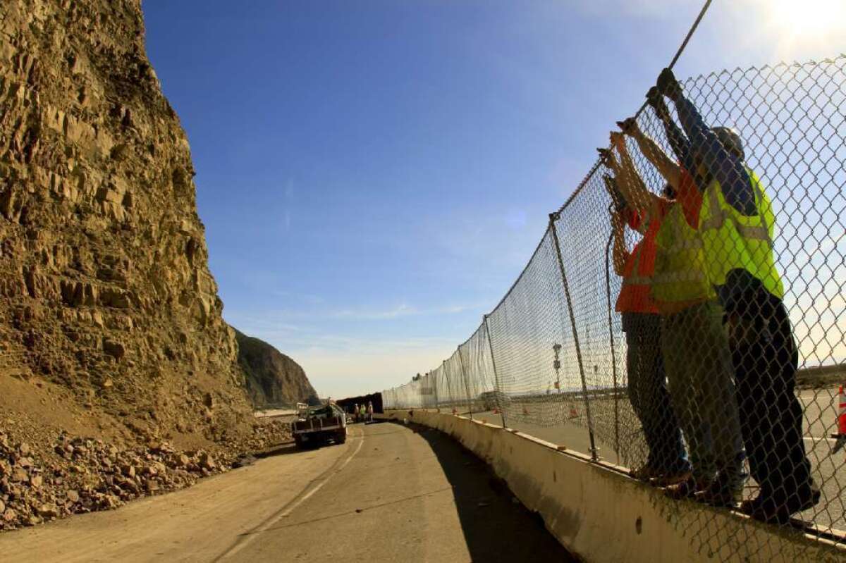Crews erect a fence on Pacific Coast Highway near Sycamore Canyon in 2010.