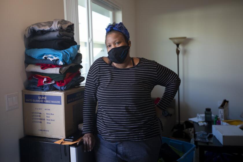 NORTH HILLS, CA - DECEMBER 02: Natosha Johnsonmoves inside her new home on Wednesday, Dec. 2, 2020 in North Hills, CA. During the global pandemic famlies move into a new building that was purchased through a much lauded state program to amp up the building of homeless housing. (Francine Orr / Los Angeles Times)