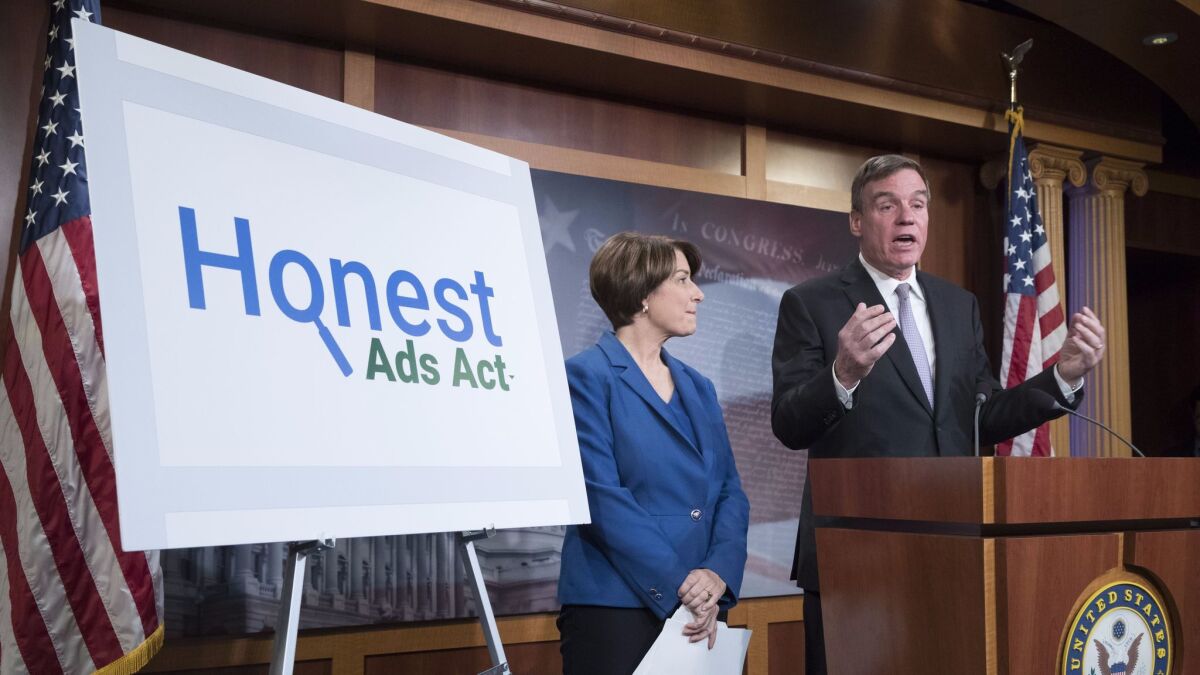 Senators Mark Warner (D-Va.) and Amy Klobuchar (D-Minn.) introduce the 'Honest Ads Act' at a news conference on Capitol Hill in Washington on Oct. 19.