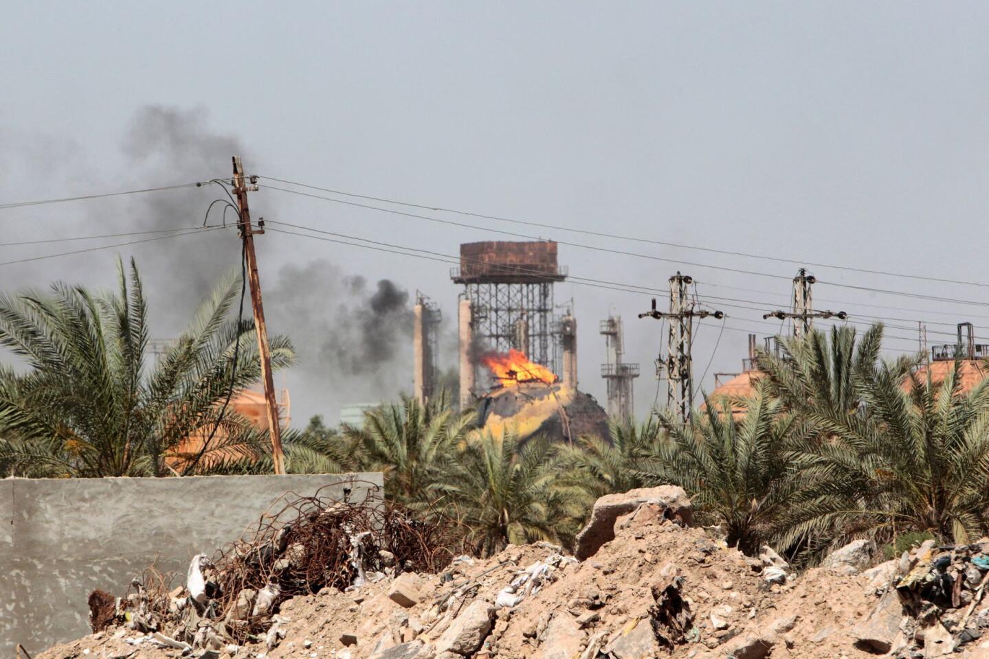 Flames and smoke rise from tanks after a suicide bomb attack on the Taji gas plant, about 12 miles north of the Iraqi capital Baghdad, on May 15, 2016.