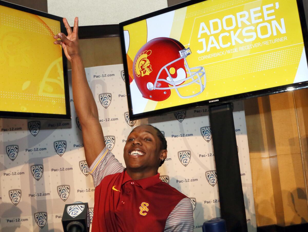 USC cornerback Adoree' Jackson flashes a "Fight On" sign as Coach Clay Helton (not shown) mentions him at the Pac-12 Conference media days on Thursday.