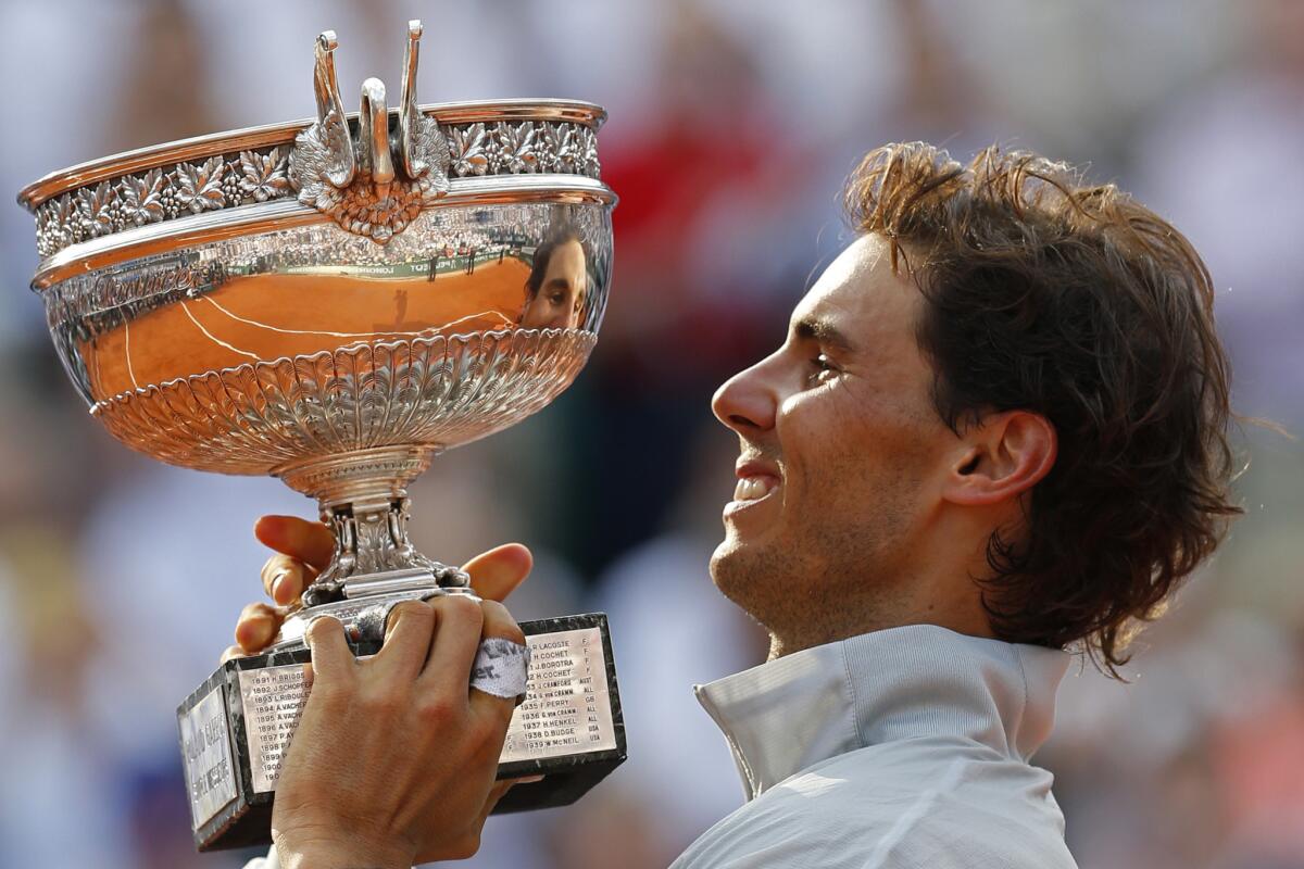 Rafael Nadal hoists the winner's trophy after defeating Novak Djokovic in four sets in the French Open championship match on Sunday.