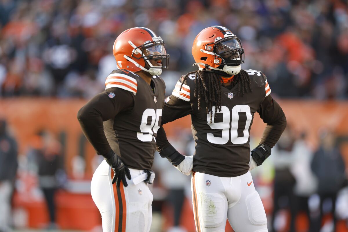FILE - Cleveland Browns defensive end Myles Garrett (95) and linebacker Jadeveon Clowney (90) play against the Baltimore Ravens during the second half of an NFL football game, Sunday, Dec. 12, 2021, in Cleveland. Myles Garrett doesn't want Jadeveon Clowney chasing quarterbacks and wrecking games with anyone else or anywhere else. “I want him here,” Garrett said.(AP Photo/Ron Schwane, File)
