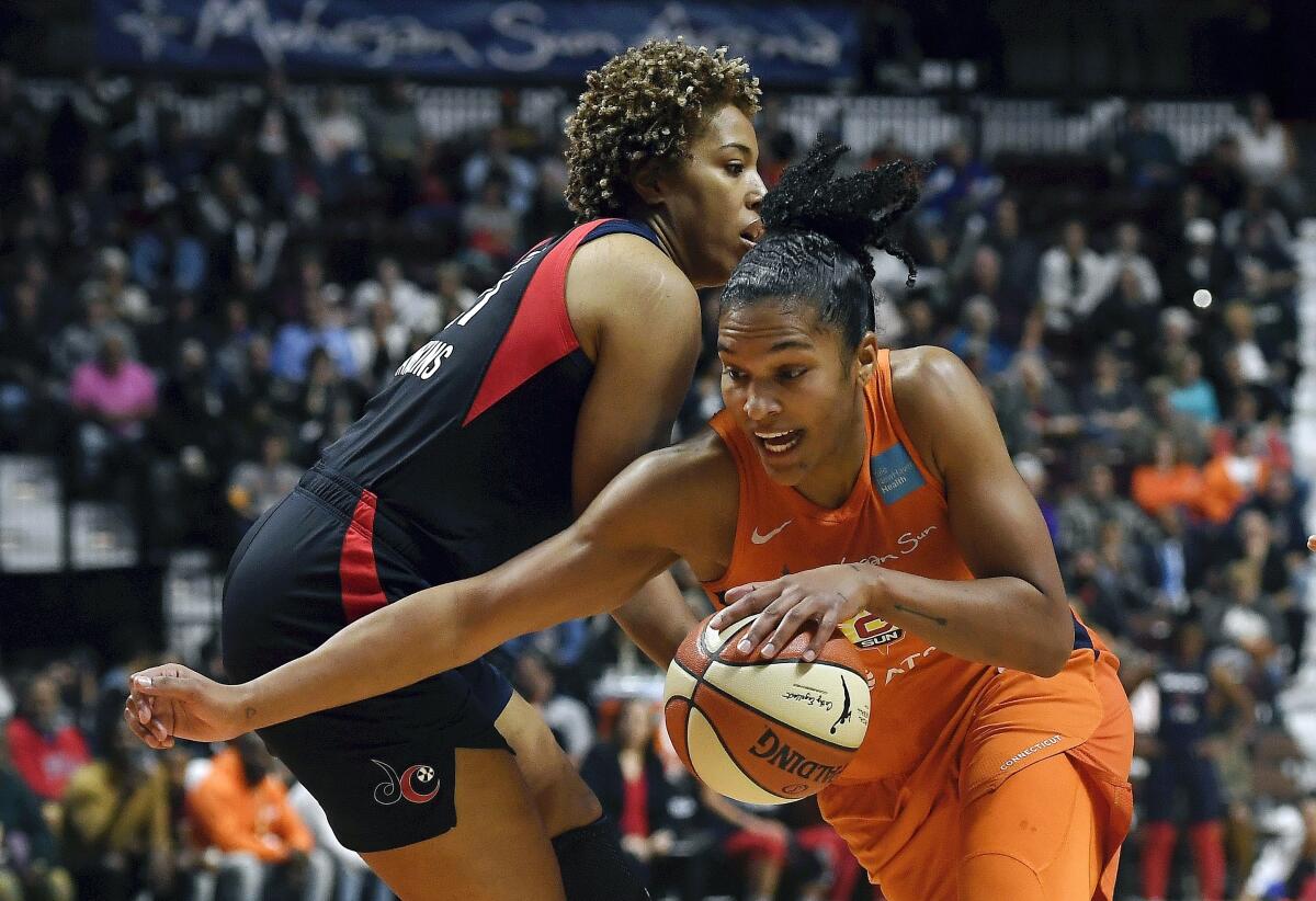 Connecticut Sun's Alyssa Thomas, front, drives past Washington Mystics' Tianna Hawkins during the first half in Game 4 of the WNBA Finals on Tuesday in Uncasville, Conn.