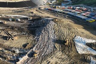 Castaic, CA - February 22: An aerial view of trucks unloading, heavy equipment spreading trash over a hill and roughly 100 metal storage containers storing contaminated or polluted water, holding up to 20,000 gallons each as the result of an underground landfill fire at Chiquita Canyon Landfill in Castaic Thursday, Feb. 22, 2024. Around 200,000 gallons of the contaminated water is coming out of the landfill each day. Environmental regulators have found elevated levels of cancer causing Benzine in the polluted water spilling onto the surface of the landfill. Landfill operators are also constructing a drainage system to capture the contaminated water that is spilling onto the surface and proactively pumping the water. Residents of Val Verde and Castaic are protesting to call for Chiquita Canyon Landfill to be closed in Hasley Canyon Park in Castaic. Garbage has been burning deep inside the landfill due to a chemical reaction for much of the past year, and recently scalding-hot contaminated water has surged to the surface. The protest follows calls from the County Supervisor Kathryn Barger's office, which said the landfill should provide funds to relocate residents who want to temporarily move until the issue is resolved. (Allen J. Schaben / Los Angeles Times)