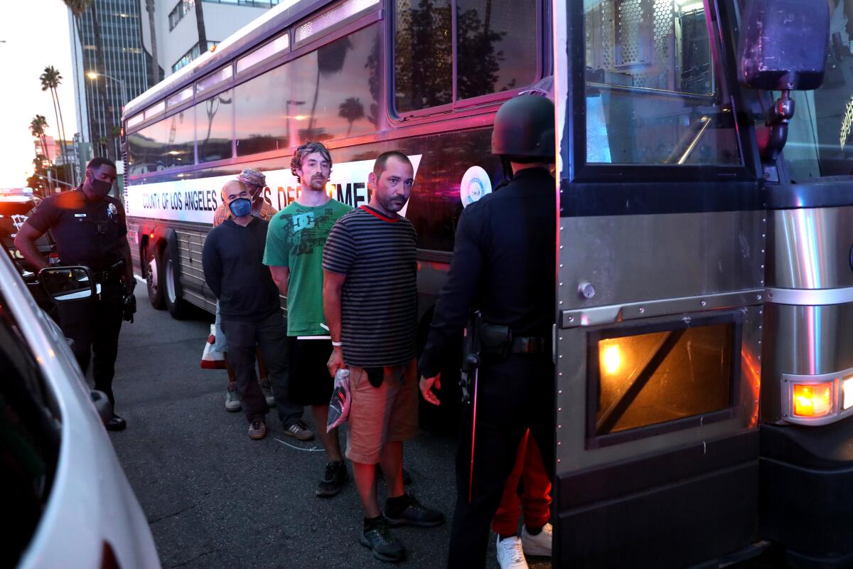 Protesters arrested for violating curfew are loaded onto a bus.