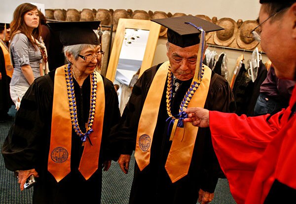 UCLA professor Don Nakanishi, right, checks the leis worn by Yuri Lily Nemoto, left, and Herbert Takashi Murayama. They were among 48 Japanese Americans who were awarded honorary degrees, some posthumously, because their education at UCLA was stopped in February 1942 when federal orders sent them to internment camps.