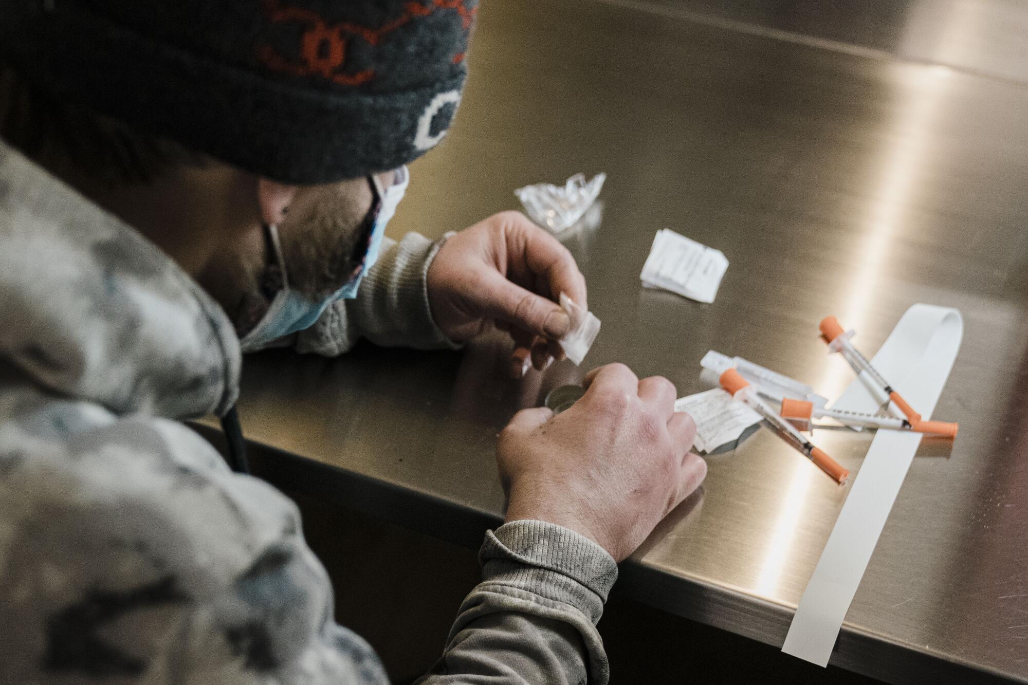 A man prepares to shoot up heroin.