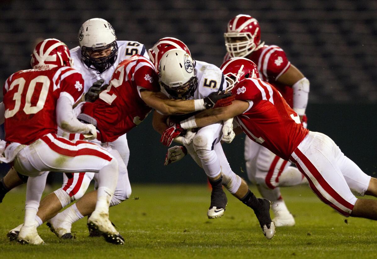 Mater Dei's Jared Wilson (32) and Julio Hernandez tackle St. John Bosco running back Sean McGrew during the Pac-5 Division championship game at Angel Stadium last December.