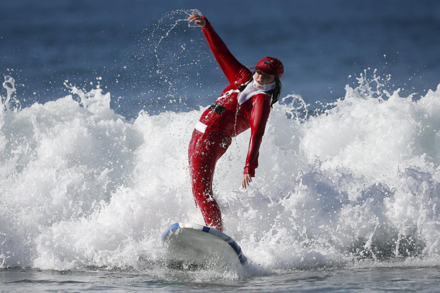 A competitor surfs dressed as Santa Claus during the ZJ Boarding House Haunted Heats Halloween Surf Contest in Santa Monica