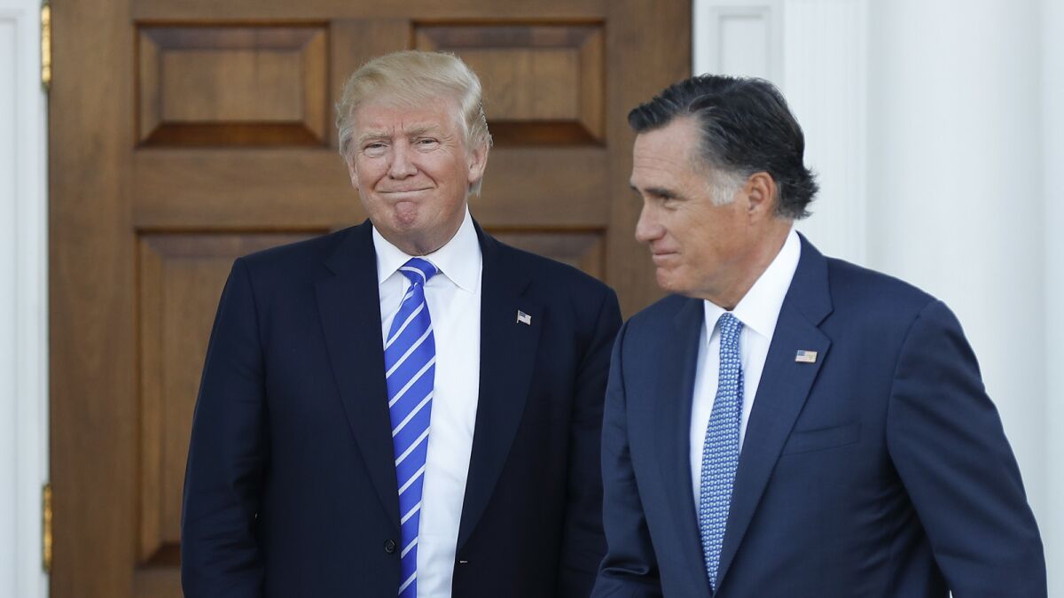 Then-President-elect Donald Trump looks on as Mitt Romney leaves a meeting at the Trump National Golf Club Bedminster on Nov. 19, 2016.