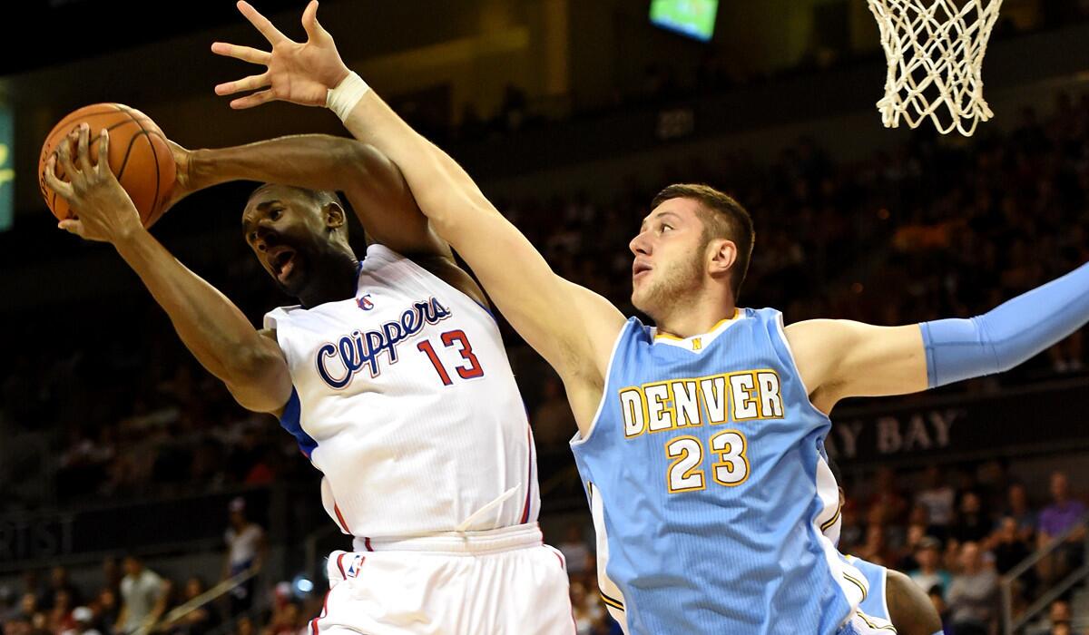 Clippers center Ekpe Udoh (13) grabs a rebound from Nuggets center Jusuf Nurkic during a preseason game.