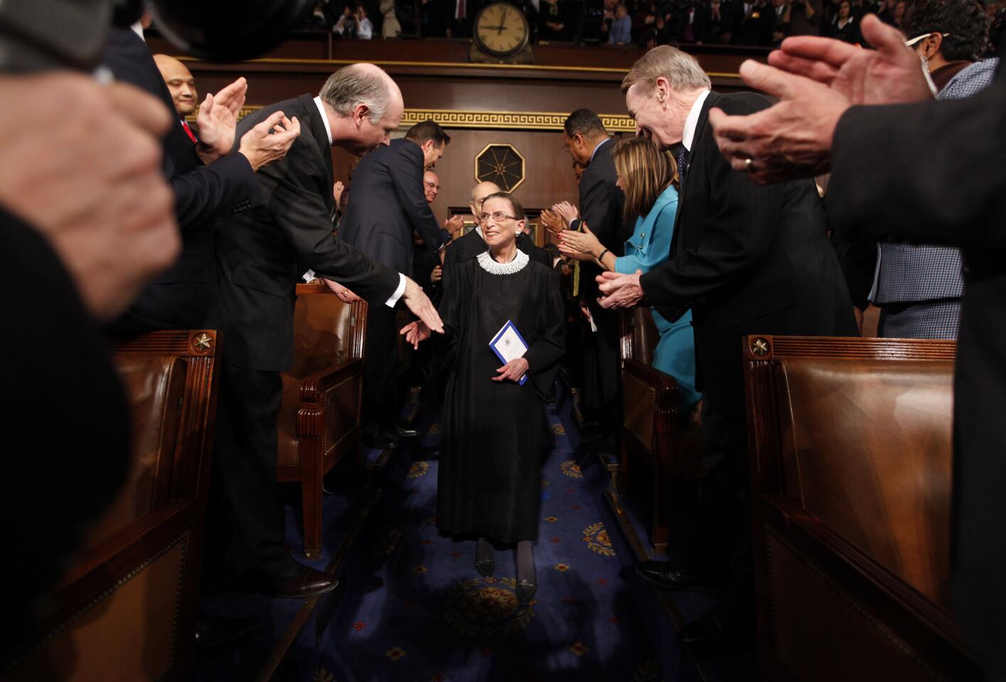 Ruth Bader Ginsburg walks down the aisle in the U.S. House chamber shaking hands with lawmakers