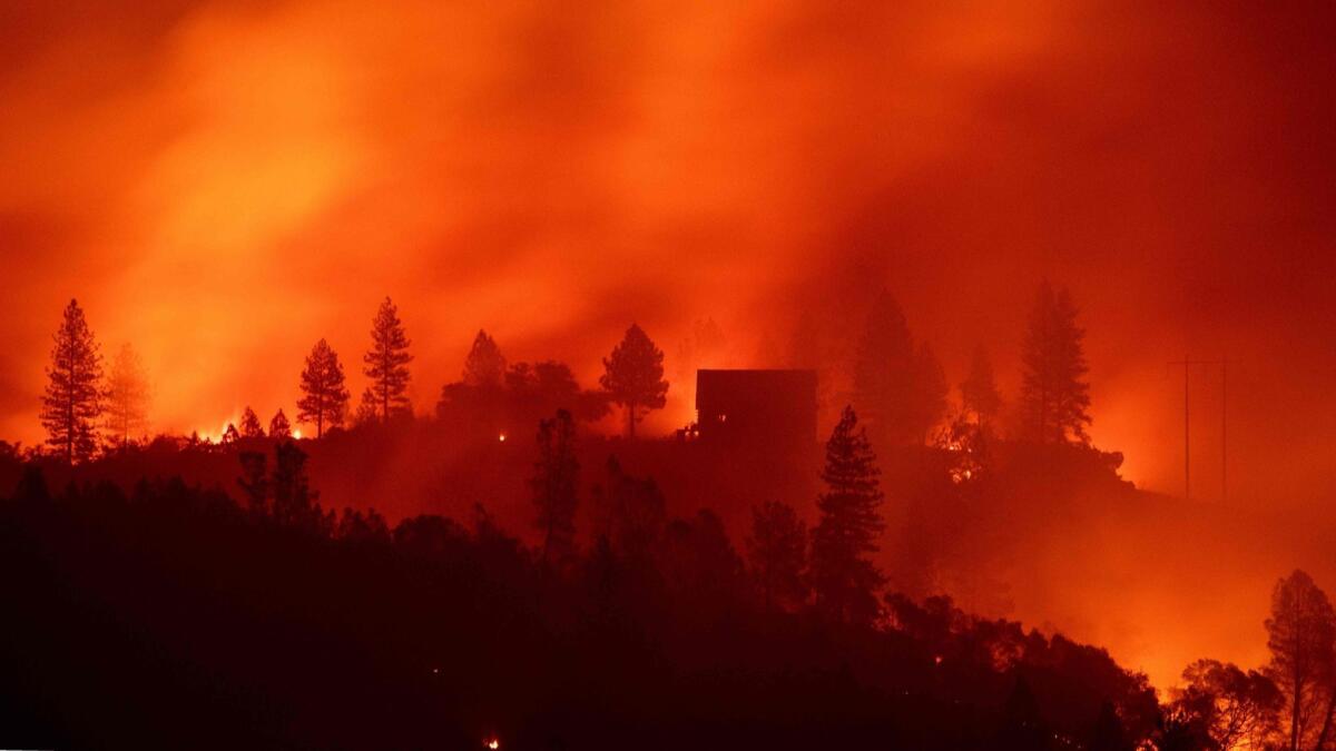 Flames from the Camp fire burn near a home atop a ridge near Big Bend, Calif., on Nov. 10.