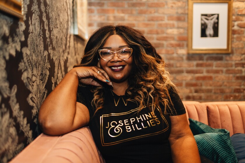 Whitney Beatty sitting on a couch at her Exposition Park dispensary