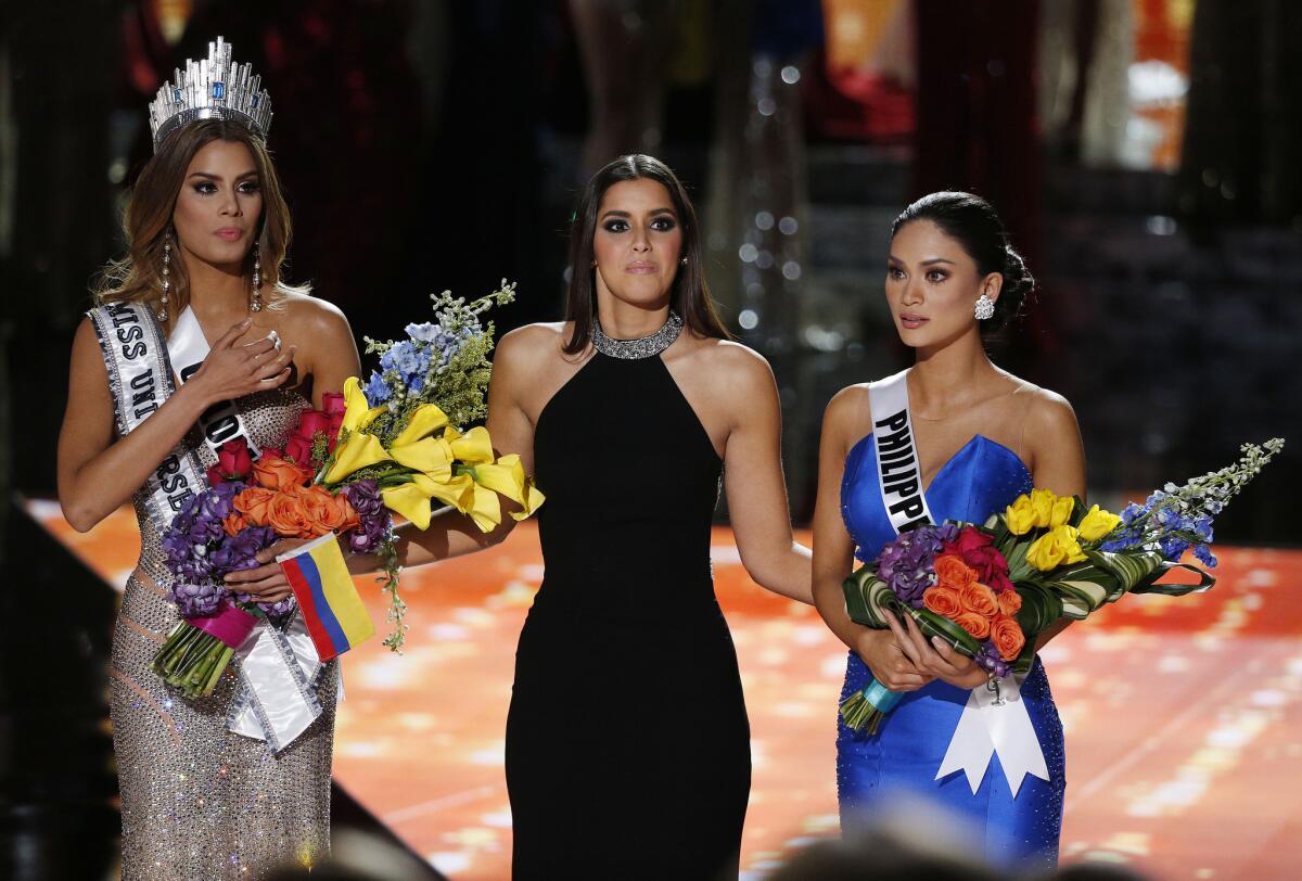 Miss Universo 2014 Paulina Vega, centro, reacciona antes de retirar la corona y las flores a Miss Colombia Ariadna Gutiérrez, izquierda, para entregárselas a Miss Filipinas Pia Alonzo Wurtzbach, derecha, en el concurso Miss Universo el domingo 20 de diciembre de 2015 en Las Vegas. Gutiérrez fue nombrada ganadora por error antes de que Wurtzbach recibiera la corona de Miss Universo. Gutiérrez restó importancia al error el martes 22 de diciembre de 2015. (Foto AP/John Locher)