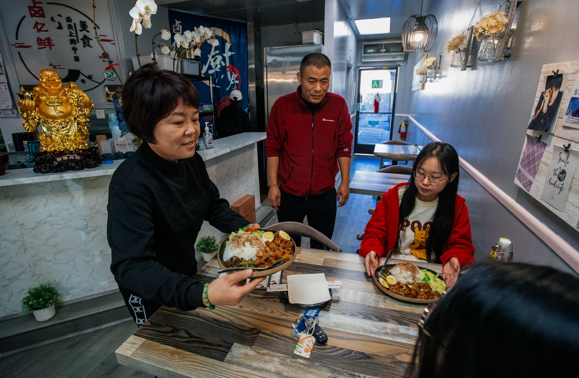The owners serve a customer inside their main dining room.