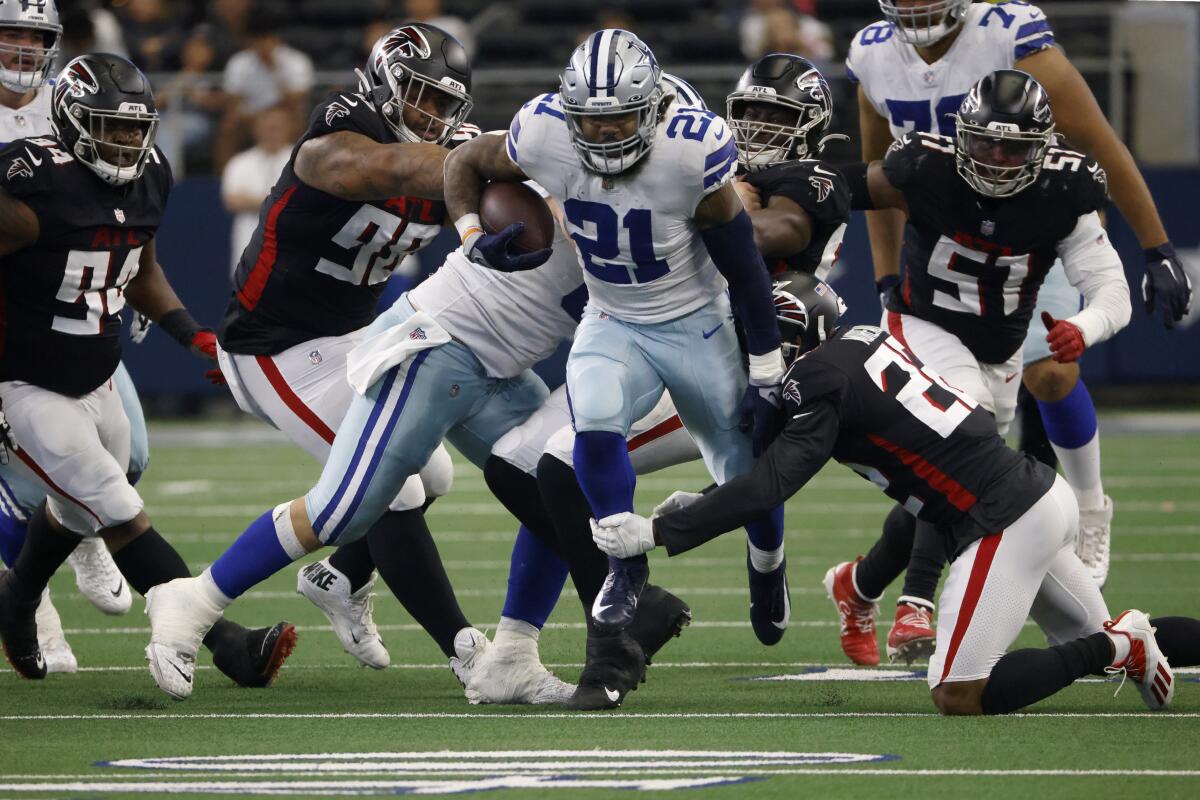 Dallas Cowboys running back Ezekiel Elliott breaks a tackle by Atlanta Falcons cornerback Fabian Moreau.
