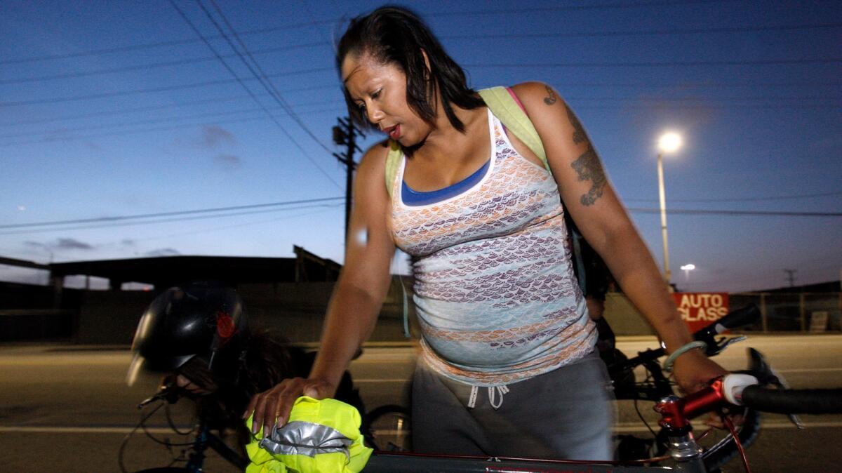 Pauletta Pierce makes a make-shift seat after her bike seat fell off during a bike ride with other female riders and some members of the Ovarian Psycos.